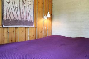 a bedroom with a purple bed in a wooden wall at Kero 15 in Syöte