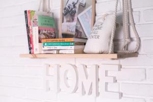 a shelf with books and a sign that reads home at DREAM Hostel Lviv in Lviv