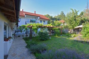 a garden with a pergola and a house at Bistra Guest Rooms in Kranevo