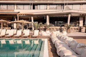 a swimming pool with lounge chairs and a building at Sunny Beach Club - Adults Only in Sunny Beach