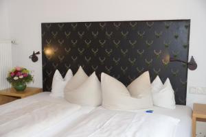a bedroom with a white bed with white pillows at Hotel & Gasthof Fraundorfer in Garmisch-Partenkirchen
