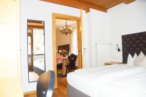 a bedroom with a bed and a table and a mirror at Hotel & Gasthof Fraundorfer in Garmisch-Partenkirchen