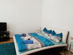 Cama blanca con sábanas y almohadas azules en Nina, en Viena