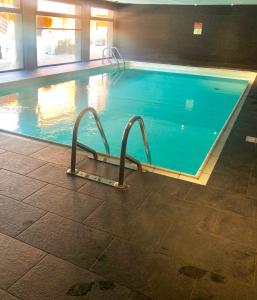 Résidence Le Pic de l'Ours في فونت رومو: حمام سباحة كبير مع سريرين في مبنى