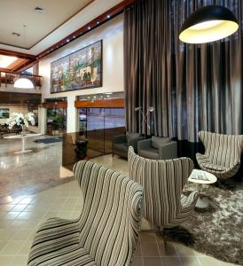 a living room filled with furniture and a large window at Oft Tamandaré Plaza Hotel in Goiânia