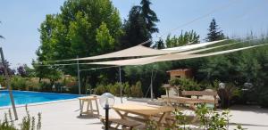 um dossel branco sobre um pátio com piscina em Villa Belfiore em Ostellato