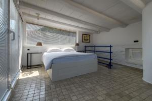 ein weißes Schlafzimmer mit einem Bett und einem Fenster in der Unterkunft Apartment Sebastijan in Piran