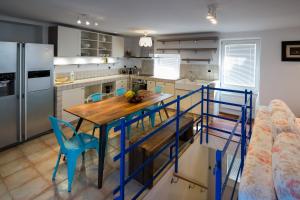 a kitchen with a wooden table and blue chairs at Apartment Sebastijan in Piran
