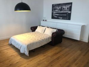 a bedroom with a bed with a couch and a lamp at Center Apartment, Vilnius, Old Town in Vilnius