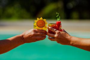 duas mãos a segurar um copo de fruta e legumes em Santa Rosa Pantanal Hotel em Pôrto Jofre
