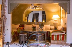 a living room with a couch and a mirror at Riad L'Evidence in Marrakech