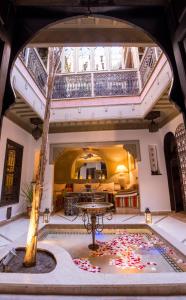 une grande chambre avec une table et un arbre dans l'établissement Riad L'Evidence, à Marrakech