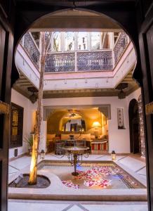 Habitación grande con una mesa y un árbol en el medio en Riad L'Evidence, en Marrakech