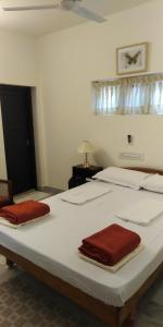 een slaapkamer met een groot wit bed met rode handdoeken erop bij Padamadan homestay in Cochin