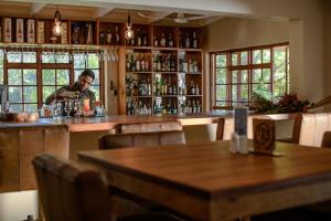 a man standing at a bar in a restaurant at The Reserve Boutique Hotel in Hazyview