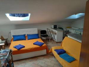 una camera con 2 letti con cuscini blu e una cucina di Viareggiomare a Viareggio