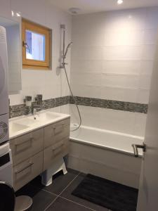 a bathroom with a tub and a sink and a shower at Chalet Les Contamines in Les Contamines-Montjoie