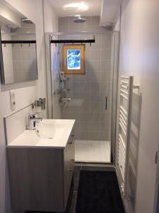 a white bathroom with a sink and a shower at Chalet Les Contamines in Les Contamines-Montjoie