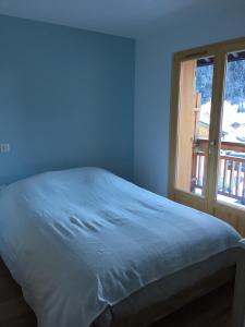 a blue bedroom with a bed and a window at Chalet Les Contamines in Les Contamines-Montjoie