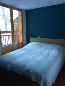 a blue bedroom with a bed and a window at Chalet Les Contamines in Les Contamines-Montjoie