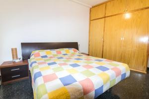 a bedroom with a colorful bed and a wooden cabinet at Biescas Doctor Fleming in Biescas