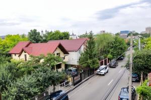 a house with a red roof and cars parked on the street at Casa Mărguța in Iaşi