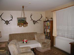 a living room with a table and chairs and antlers on the wall at Haus an der Radau in Bad Harzburg