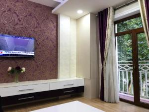 a living room with a tv on a wall at Green City Apartment 2 in Tashkent