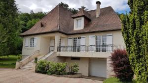 a white house with a roof and a garage at MAISON BLANCHE in Saint-Laurent-sur-Manoire