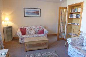 sala de estar con sofá y mesa en Tom Morris Drive en Fife