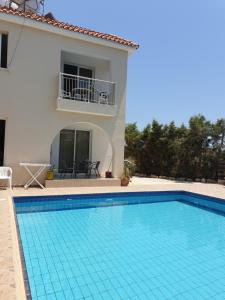 una villa con piscina e una casa di Arilena Holiday Apartments a Paphos