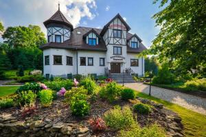 una casa antigua con un jardín delante de ella en Rezydencja Zapiecek en Świeradów-Zdrój