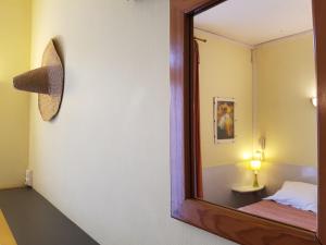 espejo en una habitación con cama y lámpara en Hôtel du Centre, en Lourdes