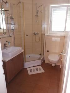 a bathroom with a shower and a toilet and a sink at Rooms Anđelka in Bol