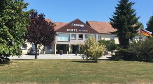 Un hotel con un coche aparcado delante. en Hotel The Originals Bernay Acropole, en Bernay