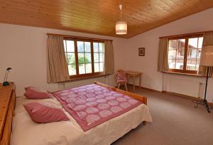 a bedroom with a bed and a desk and windows at Monami Apartments Klosters, Ferienhaus Jörgenberg in Klosters