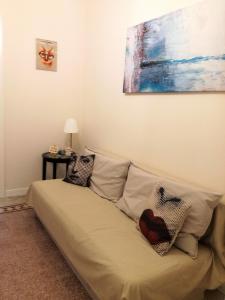 un sofá en una habitación con una pintura en la pared en Casa Elena en Ragusa
