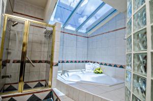 a bathroom with a tub, sink and mirror at Accra Beach Hotel in Bridgetown