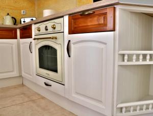 a kitchen with white cabinets and an oven at Sirena Palace Family Hotel in Obzor