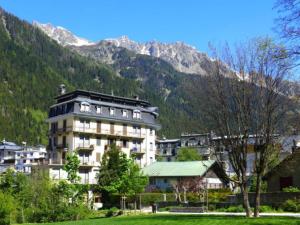 a large building in front of a mountain at Beautiful apartment in Chamonix centre with superb mountain views in Chamonix-Mont-Blanc