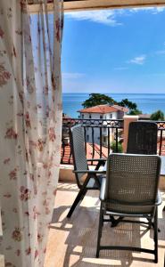 a group of chairs on a balcony with the ocean at Sirena Palace Family Hotel in Obzor
