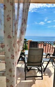 a patio with chairs and a view of the ocean at Sirena Palace Family Hotel in Obzor