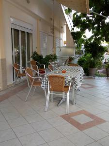 y un patio con mesa de comedor y sillas. en Hotel Ion, en Kamena Vourla