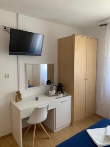 a room with a desk with a mirror and a cabinet at Kos Apartments in Bol