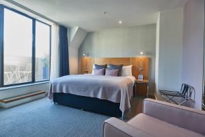 a hotel room with a bed and a large window at Apex City Of London Hotel in London