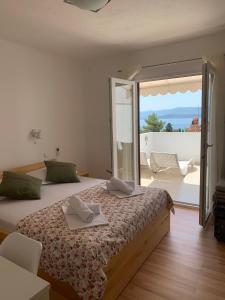 a bedroom with a bed with a view of a patio at Kos Apartments in Bol