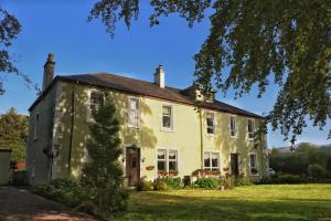 una gran casa amarilla en un patio verde en The Shielings by Inverlochy Villas, en Fort William