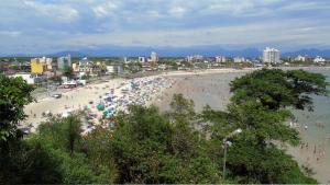 a beach with a bunch of people with umbrellas at CONFORTO e SEGURANÇA AP11 in Guaratuba