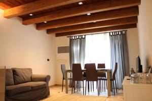 a dining room with a table and chairs and a window at L'Atelier du Temps - Les Greniers Appartements in Aosta