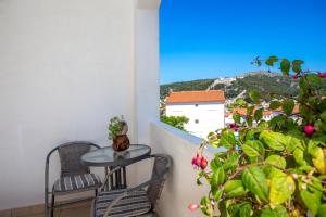 balcón con mesa, sillas y ventana en Apartments Milka, en Hvar